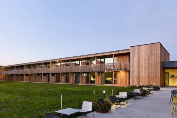 Waldstrand Hotel bei Daemmerung mit Blick auf Balkone und Terrassen