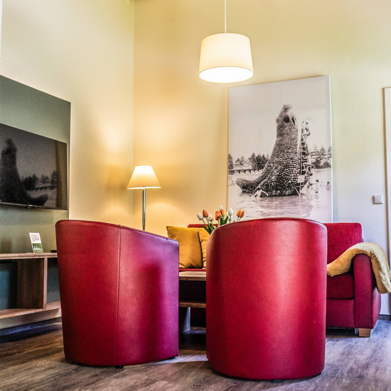 gemuetliches Wohnzimmer im Ferienhaus mit Couch und Sessel und TV