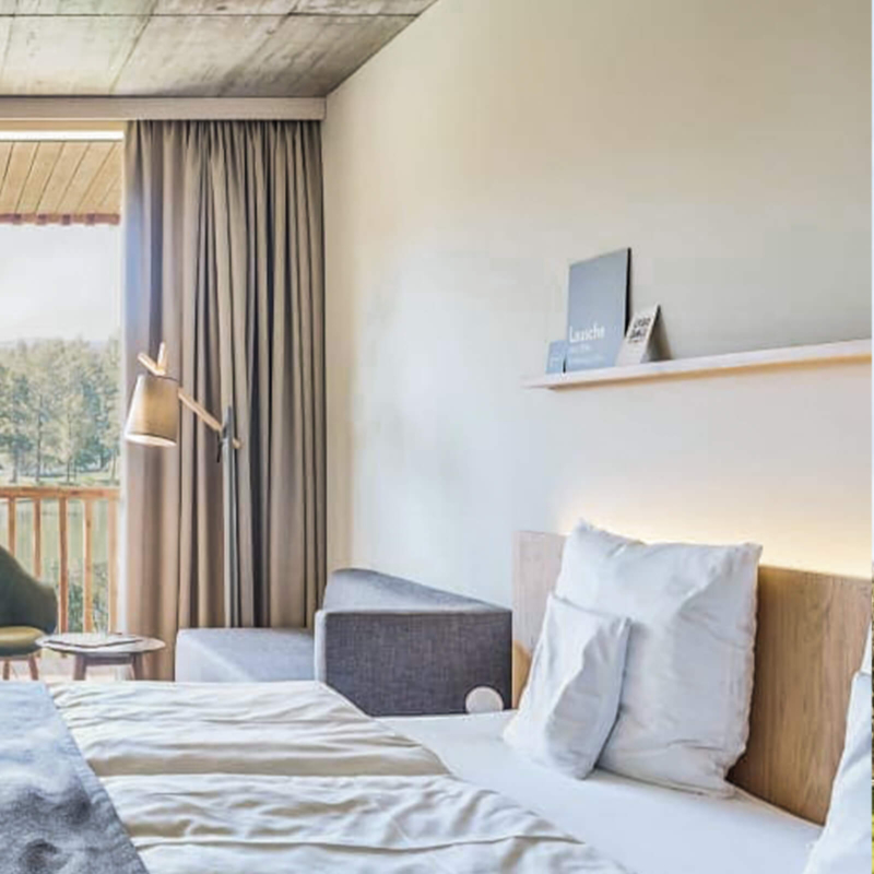 Kingsizebett mit Couch im Hotelzimmer im Trixi Park