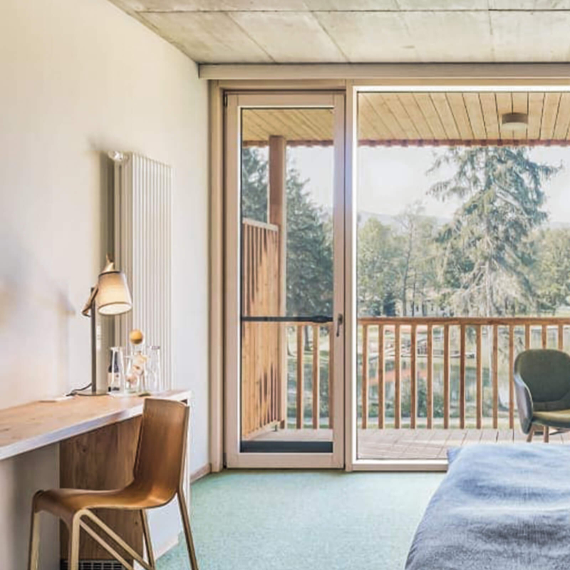 Schreibtisch, Minibar und Balkontür im Hotelzimmer im Trixi Park