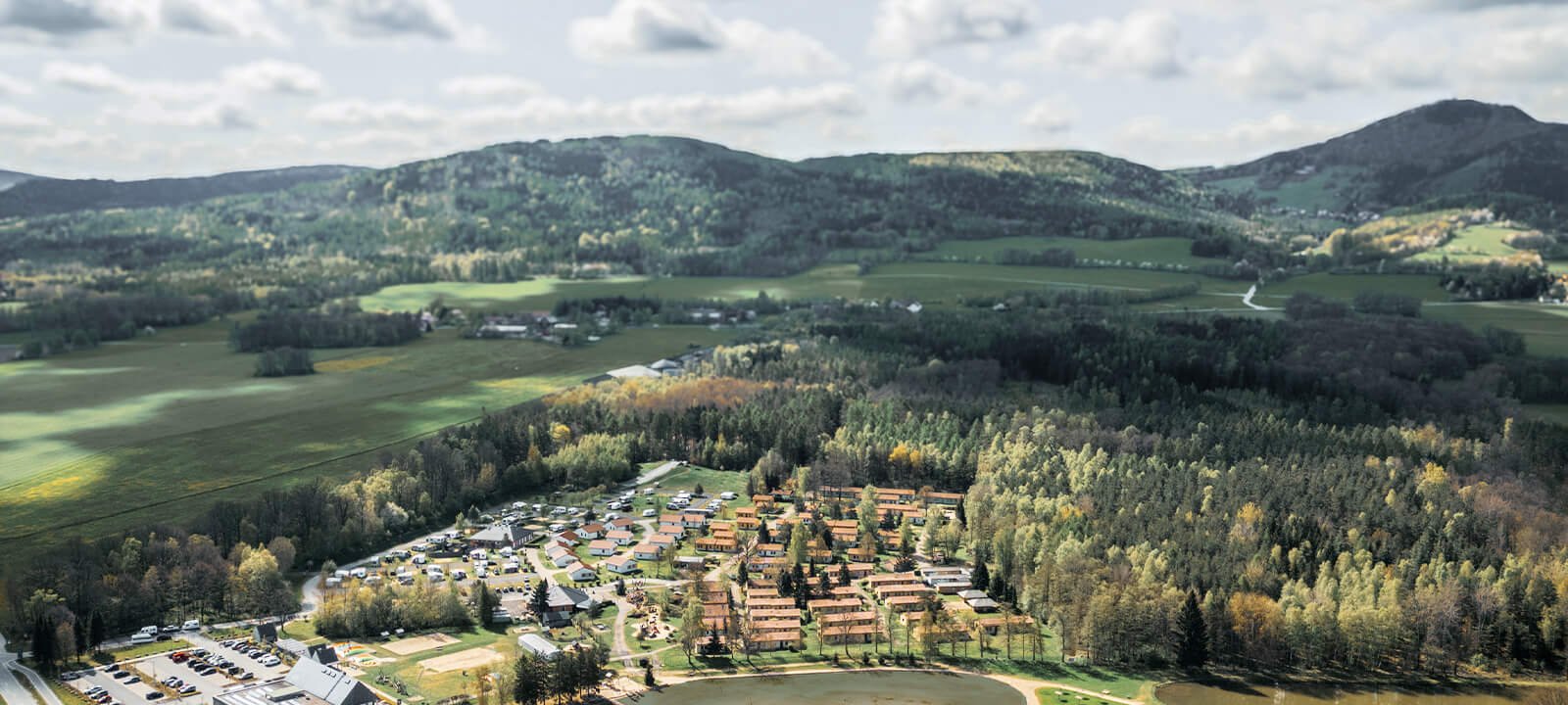 Luftaufnahme Trixi Dorf mit Ferienhaeusern, Campingplatz, Hotel und Waldstranbad mit Trixi Bad