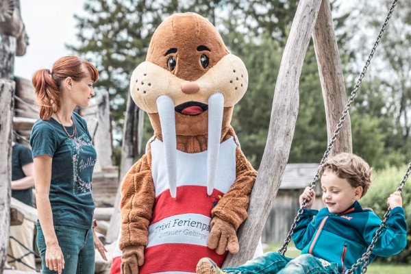 Schaukeln mit Maskottchen Trixi auf Spielplatz im Trixi Park Zittauer Gebirge