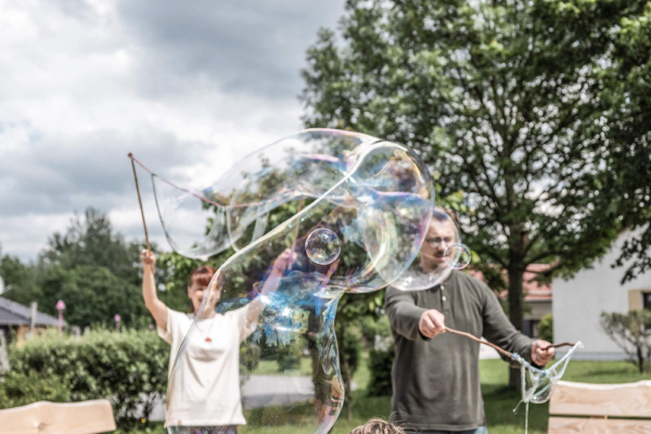 seifenblasen-animation-kidsclub-trixi-park-zittauer-gebirge Eltern lassen Seifenblasen steigen und Kind spielt mit ihnen