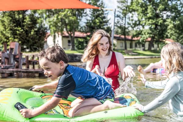 Spielen im Wasser und auf Luftmatratze im Waldstrandbad Grossschoenau