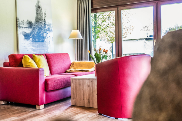 wohnzimmer-mit-couch-und-sessel-trixi-park-zittauer-gebirge-typ-c Wohnzimmer Ferienhaus mit Couch und Sessel im Trixi Park Zittauer Gebirge